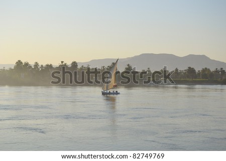 Traditional felluca boat sailing along the River Nile at dawn in the mist