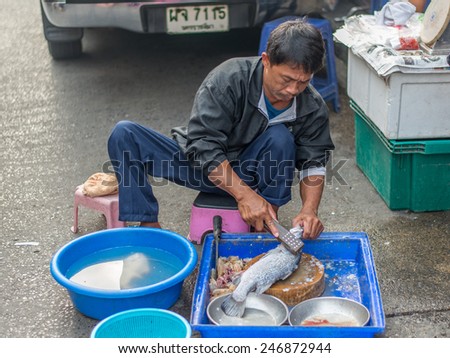 Bangkok, Thailand - January 25, 2015 Unidentified seller is cleaning fish for customer on street market in the morning at Houay Kwang area.