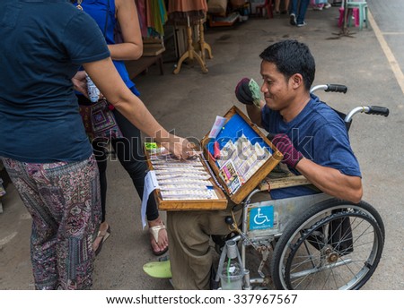 Bangkok, Thailand - Nov 7, 2015 Unidentified man on wheel chair is selling lotterry at Chatuchak, the biggest weekend market in South East Asia.
