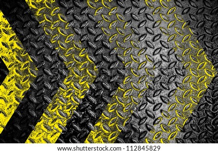Yellow and black warning sign on grunge Metal Plate