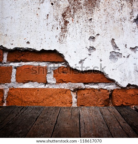 Wood floor with grunge brick wall