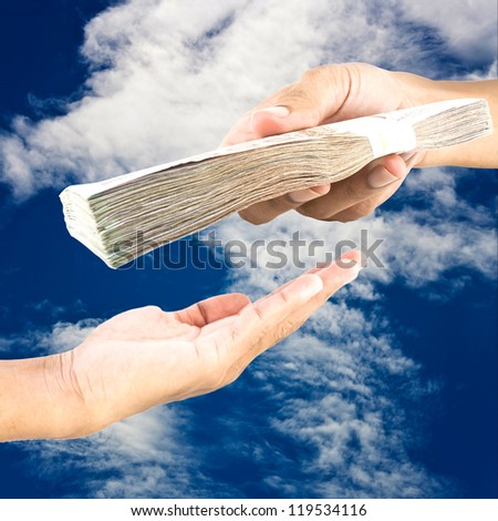 Hand handing over money to another hand on blue sky  background