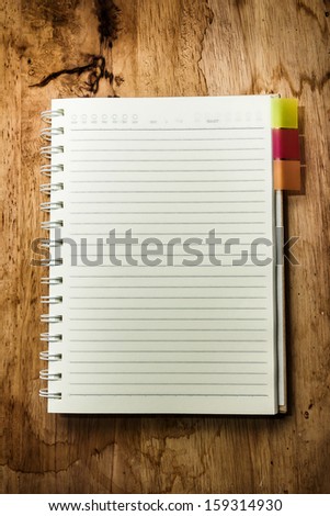 Open blank book on wooden table, blank pages with line for text.