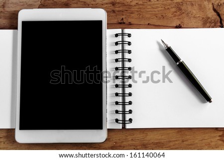 Computer screen,book and pen on wood table