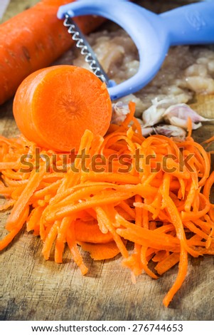Cutting carrots into strips prepare for cooking. Focus on middle carrot sticks.