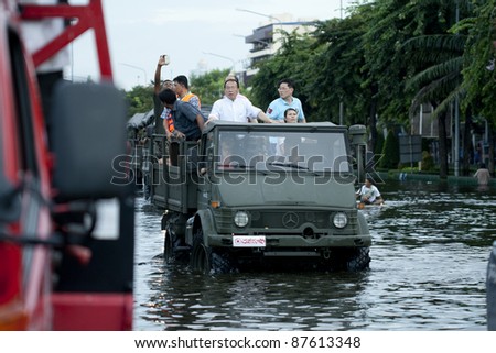 BANGKOK - OCTOBER 28: Unidentified people sit and stand in big truck to escape rising flood waters at pra pin klow bridge thonburi, in Bangkok, Thailand on Oct. 28, 2011.