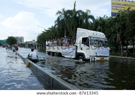 BANGKOK - OCTOBER 28: Unidentified people sit and stand in big truck to escape rising flood waters at pra pin klow bridge thonburi, in Bangkok, Thailand on Oct. 28, 2011.