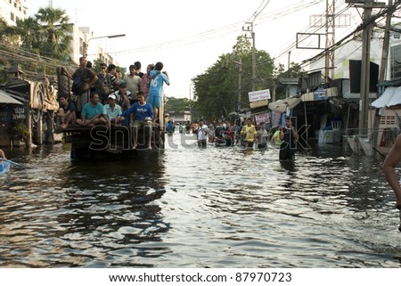 BANGKOK THAILAND - OCTOBER 31 : Unidentified people sit and stand in big truck to escape rising flood waters at jangwattana Road, Thung song hong, in Bangkok, Thailand on Oct. 31, 2011.