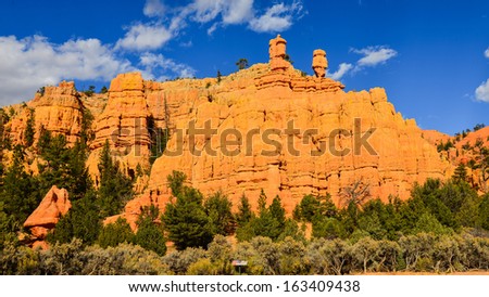 Sheer Sandstone Cliff With Two Uniquely-Formed Hoodoos - Red Canyon, Utah