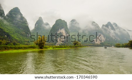 Li River And Limestone Outcrops Under Very Low Lying Clouds - Guilin, China