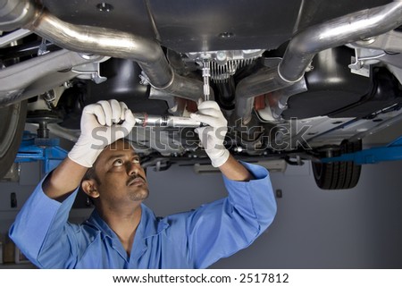 auto mechanic working under the car