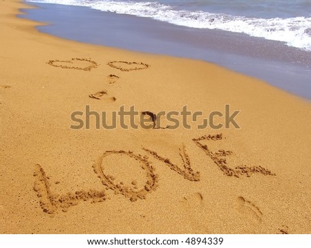 Word love and foot steps on the sand beach and sea