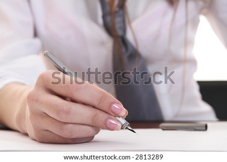 Hand of the young business woman holding in a hand the pen