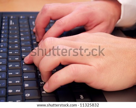 Closeup of a man typing on a laptop computer