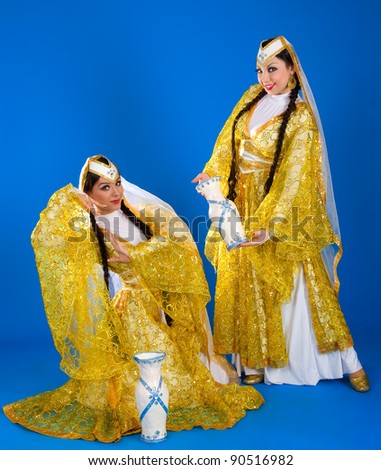 Two girls in Iranian costumes on a blue background
