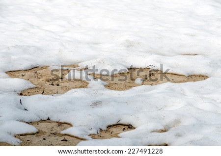 Melting snow on sandy beach of Upper Peninsula, Michigan