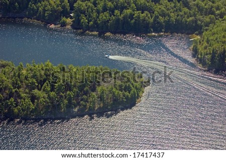 Small boat tracks on surface of water in sunlit