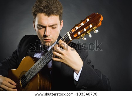 Guitarist. Man playing guitar on black background