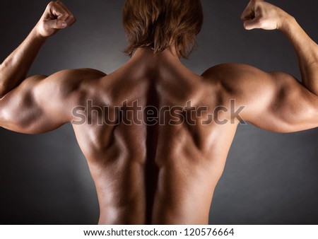 The muscular male back on black background