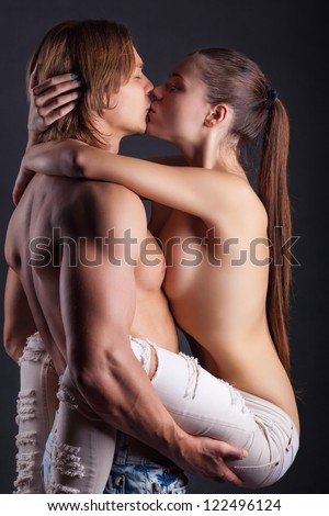 Young couple makes love on dark background