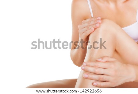 Applying moisturizer cream on the legs isolated on white background Applying moisturizer cream on the legs isolated on white background
