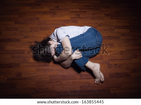 Lying on the floor of a lonely young woman in a empty room