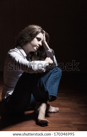 Sad woman sitting alone in a empty room