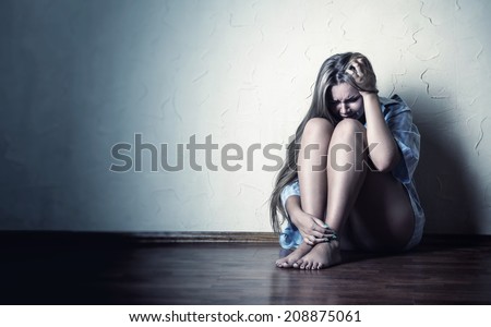 Sad woman sitting alone in a empty room