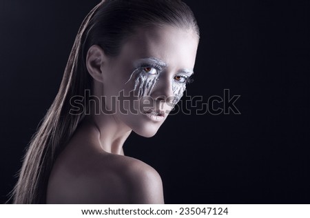 Portrait of a beautiful woman with fantasy makeup on a black background