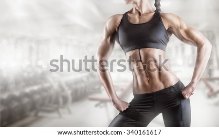 Close-up of a woman\'s body bodybuilder in the gym