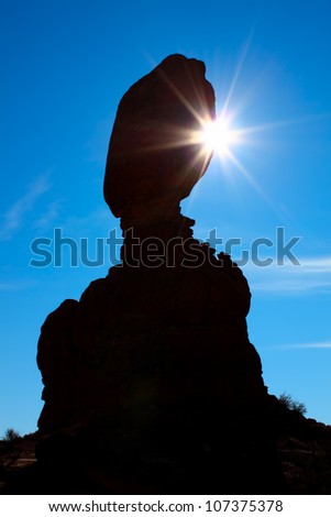 Sunlight shines from behind Balanced Rock at Arches National Park in Utah