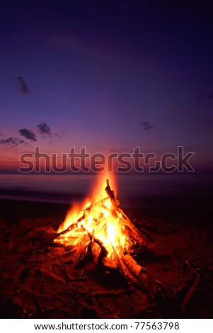 Blazing campfire at sunset along the beautiful beach of Lake Superior in northern Michigan