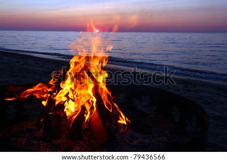 Blazing campfire at sunset along the beautiful beach of Lake Superior in northern Michigan