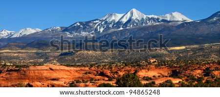 Snowcapped Mount Tukuhnikivatz of the Monti-La Sal National Forest rises above the red rock landscape in Utah
