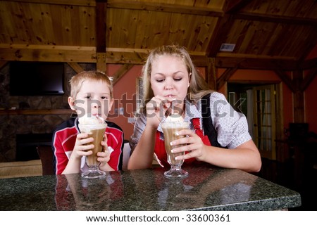 A mother an child drink root beer floats.