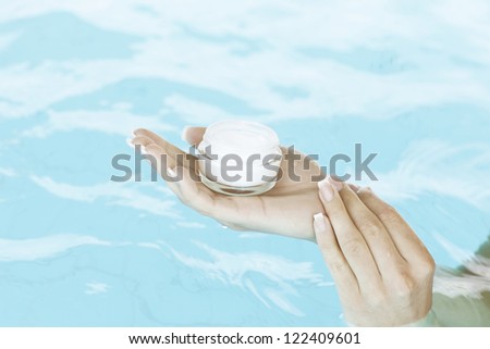 Moisturizing Hand Cream. Female hand holding cosmetic.