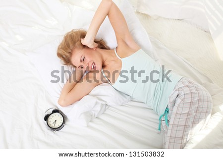Good morning! Young woman wakes up in the morning in bed.