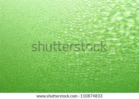 Various sizes green water drops. Water drops getting smaller toward lower left.