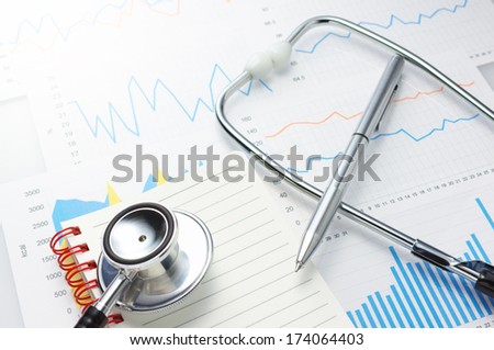 Investigation of daily health conditions. Close up of graphs, stethoscope, notebook and pen.