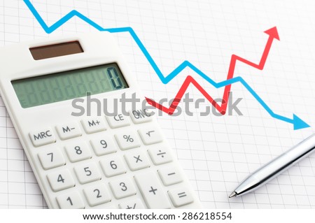 Calculator and pen on the background of line graph. Calculating, graphing and planning.