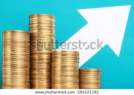 Pile of coins and growing arrow. Make money. Growing income. Pile of 500 yen coins with upside growing arrow. Blue green background.