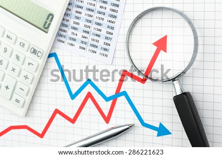 Graph, chart, magnifying glass, calculator and pen. Looking growth field of line graph with magnifying glass. Line graph and magnifying glass. Analyzing data.
