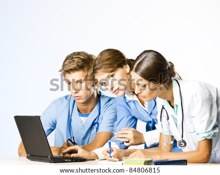 Doctor and nurses discussion at doctors office at laptop desk