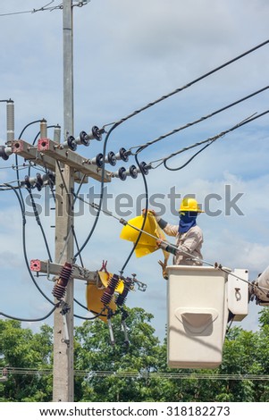 electrical utility worker in a bucket fixes a problem with a power line.