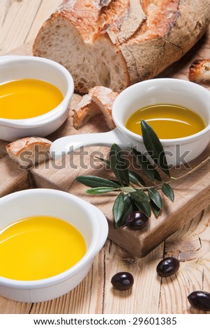 Three different kinds of olive oil with bread for tasting on a rustic wooden table