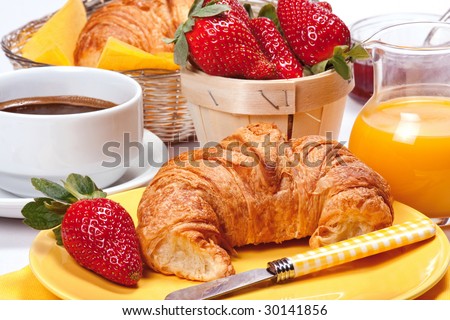 Continental breakfast. Freshly baked croissants with jam, strawberries, coffee and orange juice.