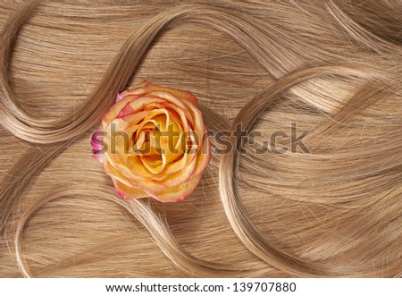 Wavy blonde human hair background with a flower