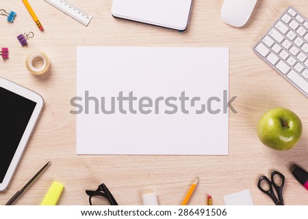 Blank sheet of paper on wooden office desk.