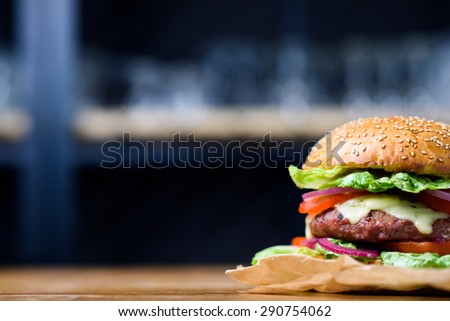 Fresh made cheeseburger with tomato, lettuce and onion.