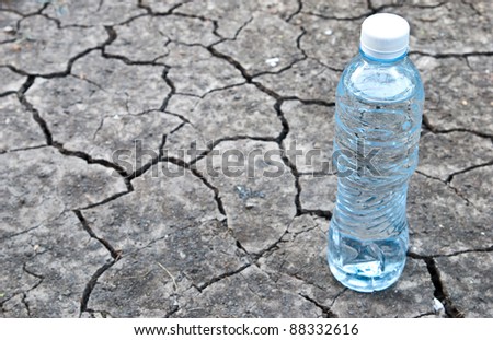 Cracked ground with water in a bottle